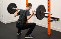 Matt Hebert, Integral massage therapist, doing back squats at the squat rack in Integral's on-site gym