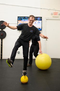 Matthew Hebert, and Integral massage therapist, balancing on a ball in the newly-built on-site gym